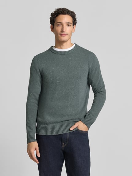 Männermodel trägt Pullover mit Tweed-Struktur von MARC O'POLO in melierter Strickoptik, Rundhals, langarm, gerippte Abschlüsse, Ganzkörperansicht von vorne.
