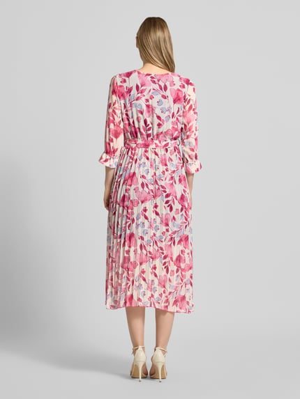 Frauenmodel trägt Midikleid mit Bindegürtel Modell 'Momoo' von ZABAIONE in Wickel-Optik mit Blumenmuster, 3/4-Arm, Rückenansicht, Kontext: Damen Midikleid, Taillierte Passform, V-Ausschnitt, Raffungen, Rückenlänge Größe S 118 cm, Brustweite 43 cm, Ärmellänge 44 cm.