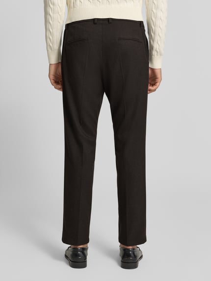 Männermodel trägt schwarze Straight Fit Stoffhose mit Viskose-Anteil Modell 'Ajend' von DRYKORN, strukturierter Look, Ganzkörperansicht Rückansicht. Herren Stoffhose, elastischer Material-Mix, Knopf- und Reißverschluss, Bundweite 42 cm, Innenbeinlänge 81 cm.