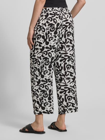Frauenmodel trägt Weite HOSE aus reiner Viskose Modell 'BARRI' von Pieces, Optik:Allover-Muster, grafisches Muster, 3/4-Länge, seitliche Eingrifftaschen, Bundabschluss: elastisch, schwarz-weiß, Ganzkörperansicht Rückansicht.