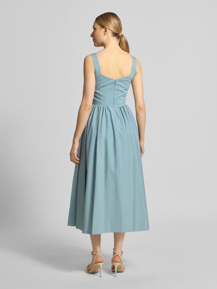 Frauenmodel trägt Cocktailkleid mit rückseitigem Reißverschluss von Jake*s Cocktail in Hellblau, Baumwoll-Mix mit Stretch-Anteil, A-Linie, Midikleid, Rückseitiger Reißverschluss, Rückenlänge bei Größe 36: 123 cm, Brustweite bei Größe 36: 40 cm, Ganzkörperansicht Rückansicht.