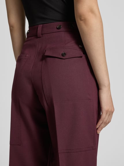 Kobiece model prezentuje Loose Fit Weite Hose aus Woll-Mix od Tommy Hilfiger, efekt: jednolity kolor, splot twill, aplikacja z logo, szerokość, kanty, szlufki na pasek, zapięcie na guzik i ukryty zamek błyskawiczny, wpuszczane kieszenie boczne, przednia mała kieszeń z patką, tylna kieszeń z patką, mieszanka wełny; zdjęcie: z tyłu, ujęcie sylwetki od pasa w dół.