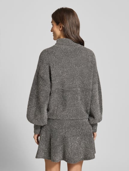 Frauenmodel trägt schimmernden Strickpullover aus Effektgarn mit Rollkragen Modell 'LISTRA' von YAS, Relaxed-Fit, Rückenlänge 59 cm, Viskose-Mix, Rückenansicht.