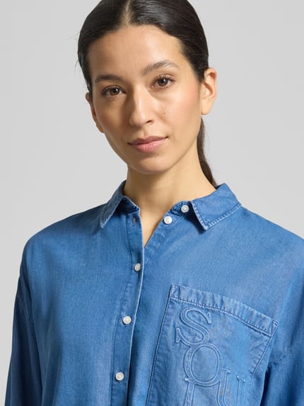 Frauenmodel trägt Boxy Fit Bluse aus Lyocell mit Label-Detail von Smith and Soul im Denim-Look, Nahaufnahme Oberkörper.