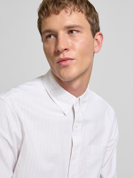 Männermodel trägt Classic Fit Freizeithemd mit Button-Down-Kragen von Calvin Klein Jeans aus Baumwoll-Elasthan-Mix, Nahaufnahme Oberkörper.