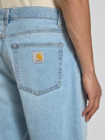 Männermodel trägt Jeansshorts mit Eingrifftaschen Modell 'Robertson' von Carhartt Work In Progress in Hellblau, Reine Baumwolle, Relaxed-Fit, Detailaufnahme Rückansicht.