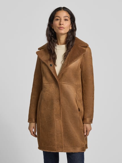 Kobiece modelka nosi brązowy płaszcz z funkcją dwustronną Mantel mit Wendefunktion Modell 'VENUS' od OAKWOOD, regular fit, z kołnierzem rewersowym; całkowity widok z przodu.