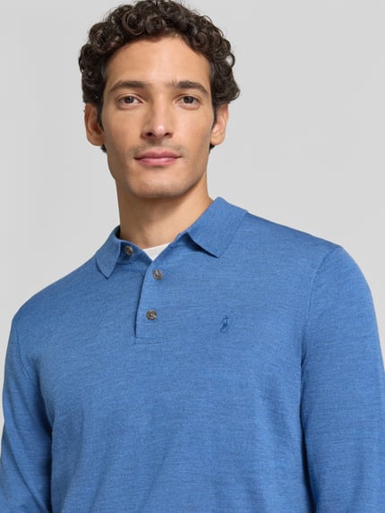 Męski model nosi Regular Fit Pullover aus reiner Wolle von Polo Ralph Lauren w kolorze niebieskim, tekstura gładka, z bliska na górną część ciała.