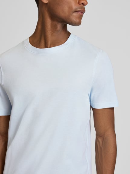 Männermodel trägt T-Shirt mit Rundhalsausschnitt von MCNEAL in Hellblau, reine Baumwolle, Slim Fit, Nahaufnahme Oberkörper.