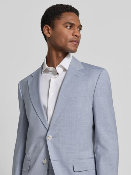 Männermodel trägt Slim Fit Anzug aus reiner Schurwolle Modell 'H-HUGE-2PCS-263' von BOSS in hellblau, glatte Textur, Nahaufnahme Oberkörper, Herren Anzug von BOSS.