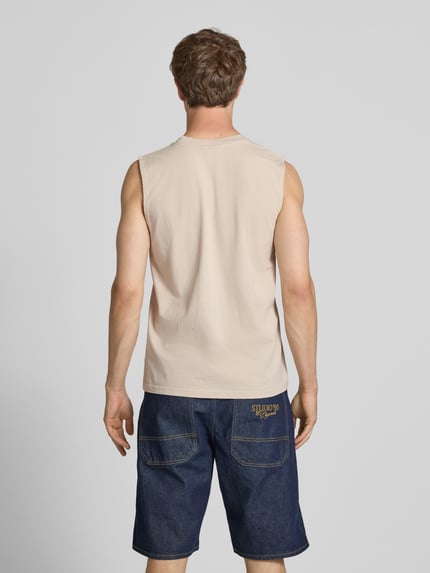 Männermodel trägt Tanktop mit Label-Stitching und Rundhalsausschnitt von Pegador, beige Farbe, reine Baumwolle, Relaxed Fit, Ganzkörperansicht Rückansicht
