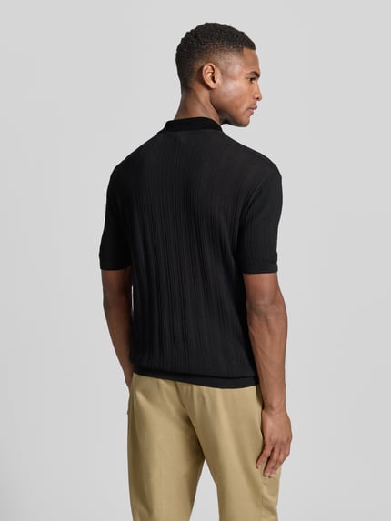 Männermodel trägt Body Fit Poloshirt mit kurzem Reißverschluss von Emporio Armani aus reiner Baumwolle in Schwarz; gerippte Abschlüsse, Rückenlänge bei Größe M 66 cm; Ganzkörperansicht Rückansicht.