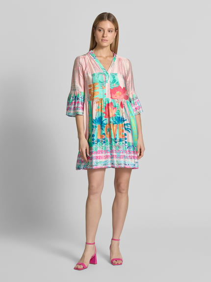Frauenmodel trägt Relaxed Fit Minikleid aus reiner Viskose Modell 'Love' von miss goodlife mit floraler Allover-Print, Halbarm, V-Ausschnitt, Rückenlänge 88 cm, Brustweite 50 cm, Ärmellänge 47 cm; Ganzkörperansicht von vorne.