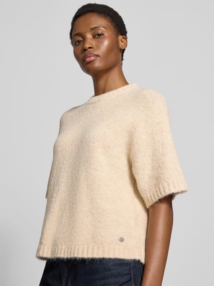 Männermodel trägt sweter z dzianiny Model 'Lotti' von GUIDO MARIA KRETSCHMER WOMAN, mieszanka materiałów z dodatkiem wełny, krój regular fit, okrągły dekolt, rękaw o dł. 1/2, kolor beżowy, strukturalna faktura, długość tyłu w rozmiarze 36: 56 cm, długość rękawów: 22 cm, Ganzkörperansicht von vorne