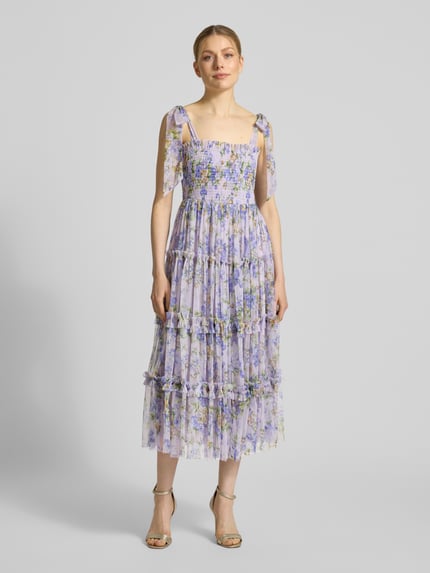 Frauenmodel trägt Cocktailkleid im Stufen-Look von LACE & BEADS aus Tüll in A-Linie mit Smok-Details, Schnürungen, florales Muster, Ganzkörperansicht von vorne. Rückenlänge bei Größe S: 102 cm, Brustweite bei Größe S: 34 cm.