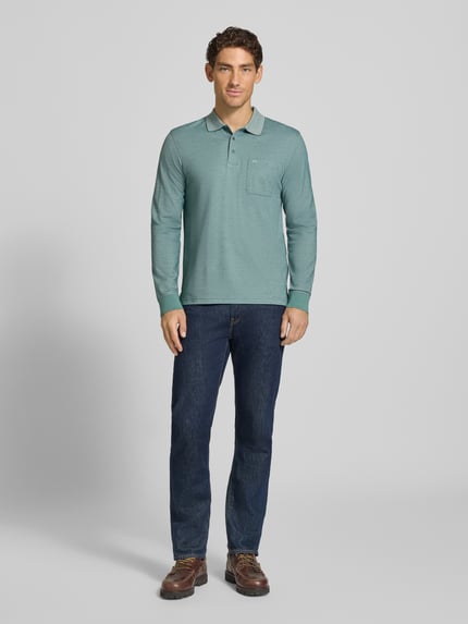 Männermodel trägt Regular Fit Poloshirt mit Baumwoll-Anteil von Christian Berg Men in Mintgrün, Langarm, Polokragen, Ganzkörperansicht von vorne.