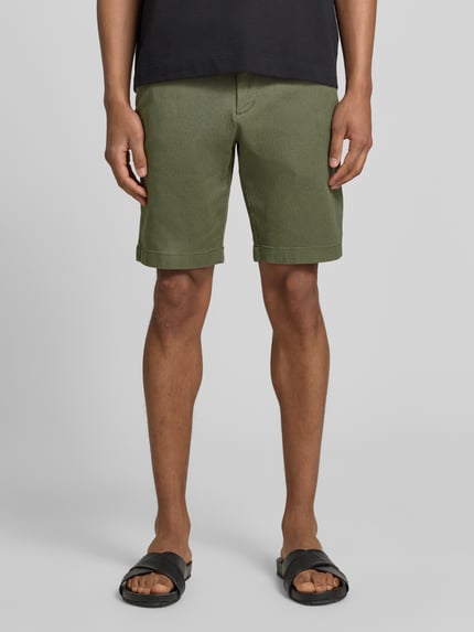 Männermodel trägt Regular Fit Chinoshorts aus Baumwoll-Mix von Tom Tailor Denim, Bi-Color Optik, Gürtel, Eingrifftaschen, Knopf und verdeckter Reißverschluss, Ganzkörperansicht von vorne.