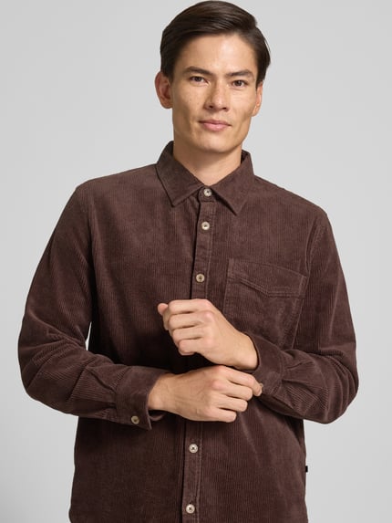 Männermodel trägt Comfort Fit Hemdjacke aus Baumwoll-Mix von s.Oliver RED LABEL, braun, feine Cordstruktur, Nahaufnahme Oberkörper.