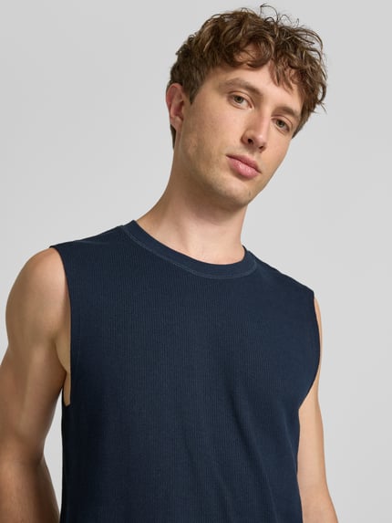 Männermodel trägt Tanktop mit Strukturmuster und Rundhalsausschnitt von Jack & Jones in Dunkelblau, reine Baumwolle, Nahaufnahme Oberkörper.