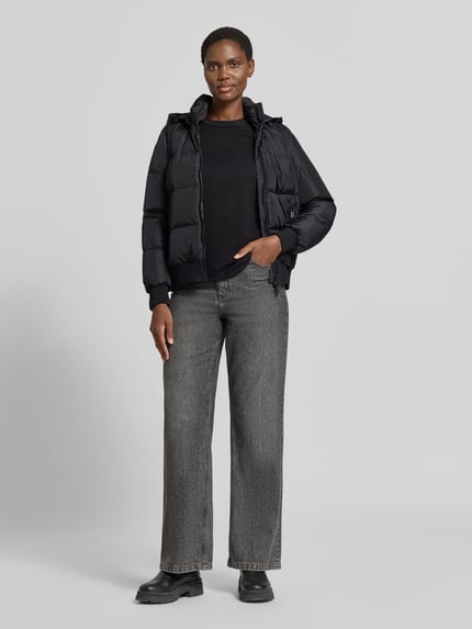 Vrouwenmodel draagt Steppjacke met Daunen-Feder-Füllung van Armani Exchange in zwart, elastische materiaalmix, regular fit, opstaande kraag, tweewegritssluiting, ritszakken, capuchon, ruglengte maat S 60 cm, schouderbreedte 41 cm, borstwijdte 50 cm, mouwlengte 62 cm, geheel van voren.