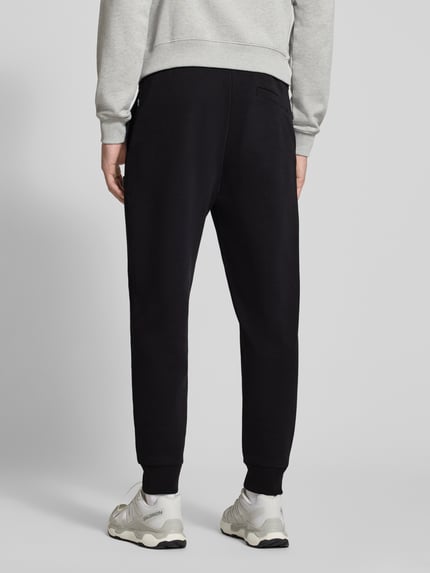 Männermodel trägt schwarze Regular Fit Sweathose aus Baumwoll-Mix Modell 'C-Locsin 01' von BOSS, Herren Sweathose, Ganzkörperansicht Rückansicht.