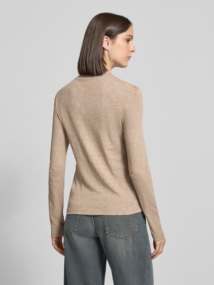 Frauenmodel trägt Langarmshirt mit Mock Neck Jersey von MARC O’POLO in melierter Beige-Optik mit strukturierter Jersey-Textur, Ganzkörperansicht Rückansicht.