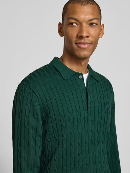 Männermodel trägt grünen Regular Fit Pullover aus reiner Baumwolle von Tommy Hilfiger mit Strukturmuster, Nahaufnahme Oberkörper, Herren Pullover von Tommy Hilfiger.