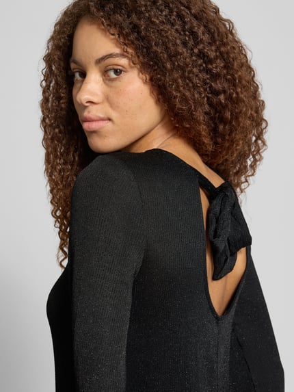 Frauenmodel trägt Langarmshirt mit Glitzerstruktur von ONLY in Unifarbe Schwarz, Jersey mit dezenter Struktur, Ausschnitt hochgeschlossen, Detailaufnahme Rückansicht.