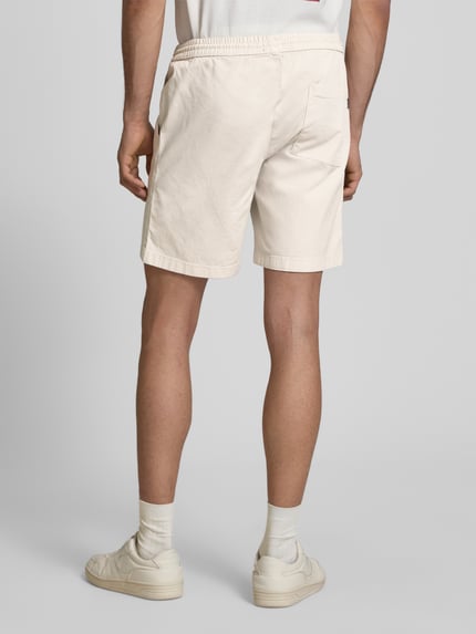 Männermodel trägt Shorts mit elastischem Bund Modell 'JAIDEN CARTER' von Jack & Jones aus Baumwoll-Elasthan-Mix, Strukturmuster, Regular-Fit, cremefarben, Rückansicht Ganzkörperansicht.
