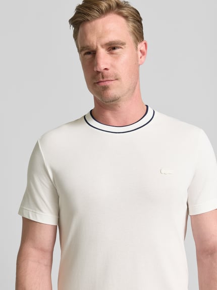 Mężczyzna nosi Regular Fit T-Shirt aus Baumwoll-Mix Modell 'CREATOR' von Lacoste, męski t-shirt w jasnym kolorze, gładka tekstura, Nahaufnahme Oberkörper.