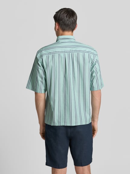 Männermodel trägt Regular Fit Freizeithemd mit Kentkragen und Brusttasche von Lindbergh, gestreiftes Baumwollmaterial, Ganzkörperansicht Rückansicht.