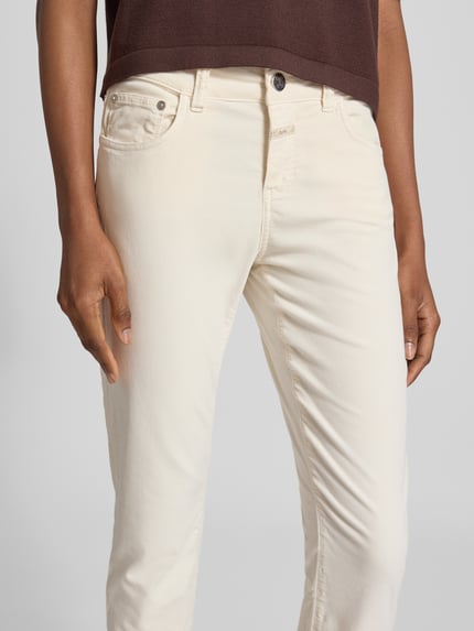 Frauenmodel trägt cremefarbene Slim Fit Jeans aus elastischem Baumwoll-Mix von Closed, Modell 'Baker', Nahaufnahme Oberkörper.