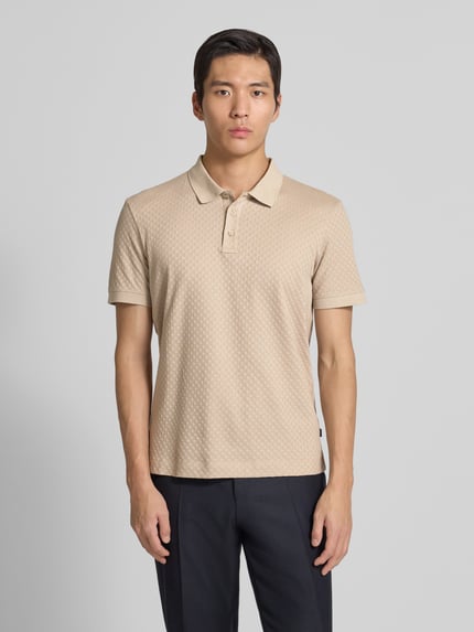 Männermodel trägt Poloshirt mit kurzer Knopfleiste Modell 'Roni' von JOOP! Collection aus reiner Baumwolle in Regular-Fit, Ganzkörperansicht von vorne.
