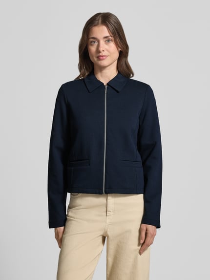 Vrouwenmodel draagt Regular Fit Kurzblazer aus Baumwoll-Mix van Tom Tailor, look: effen, pasvorm: regular fit, platte kraag, ritssluiting, lange mouw, zij-steekzakken, materiaalverwerking: ottoman-rib, Ganzkörperansicht van voren.