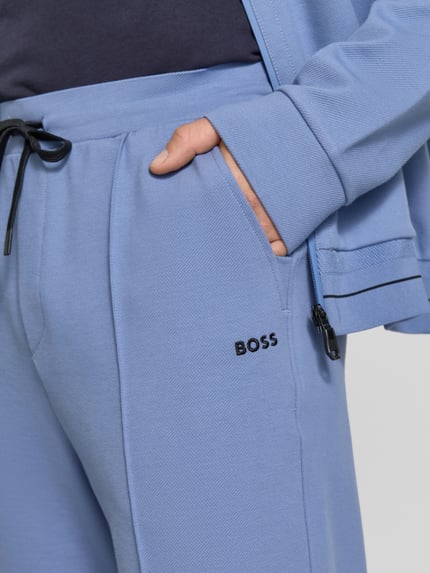 Mannenmodel draagt Regular fit sweatpants uit katoenmix model 'JT_Member Hurley' van BOSS Green, effen, label stitching, detailopname.