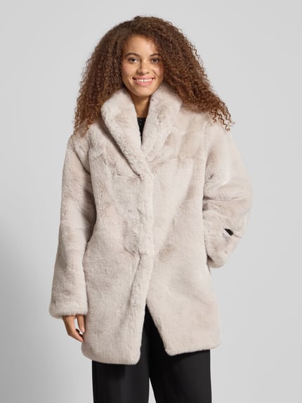 Frauenmodel trägt Mantel mit Reverskragen von Karo Kauer in hellem Kunstfell, Regular Fit, mit Label-Detail, Ganzkörperansicht von vorne. Rückenlänge 87 cm, Schulterbreite 50 cm, Brustweite 58 cm, Ärmellänge 62 cm bei Größe XS/S.