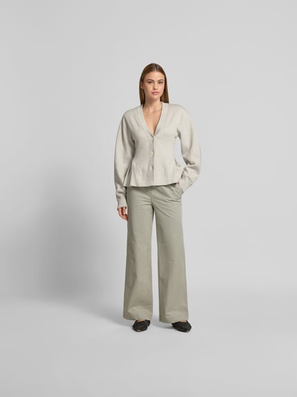 Frauenmodel trägt Wide Fit Jeans mit Tunnelzug von Juvia aus reiner Baumwolle in Beige, eingriff- und Gesäßtaschen, Ganzkörperansicht von vorne.