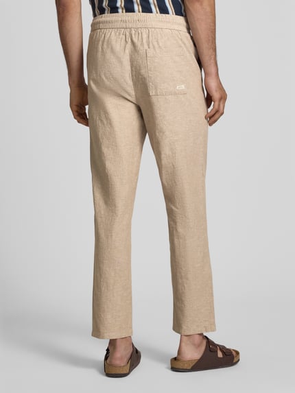 Männermodel trägt Hose aus Baumwoll-Leinen-Mix mit elastischem Bund von Blend in Beige, Regular-Fit, Modell 'ABAN', Ganzkörperansicht Rückansicht.