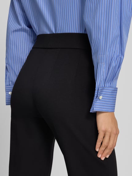 Frauenmodel trägt Regular Fit Schlaghose aus Viskose-Mix Modell 'NANOU' von SEDUCTIVE, schwarze glatte Textur, Detailaufnahme, Damen Schlaghose von SEDUCTIVE.