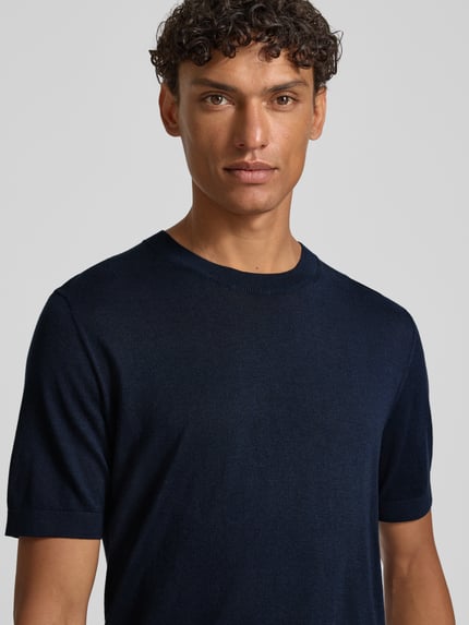 Männermodel trägt Strickshirt mit Rundhalsausschnitt und 1/2-Arm von OLYMP Level Five, Baumwoll-Lyocell-Mix, Regular-Fit, Rückenlänge bei Größe M 67 cm, Nahaufnahme Oberkörper.
