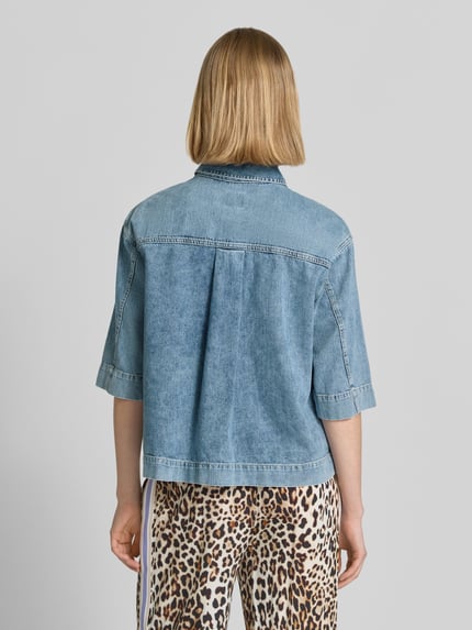 Frauenmodel trägt Relaxed Fit Hemdbluse in Denim-Optik von Emily Van den Bergh aus reiner Baumwolle, Halbarm, Ganzkörperansicht Rückansicht.