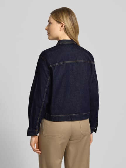 Frauenmodel trägt Regular Fit Jeansjacke aus Baumwoll-Mix von Tom Tailor in dunkler Denim-Optik mit Rückenpasse, Ganzkörperansicht Rückansicht.