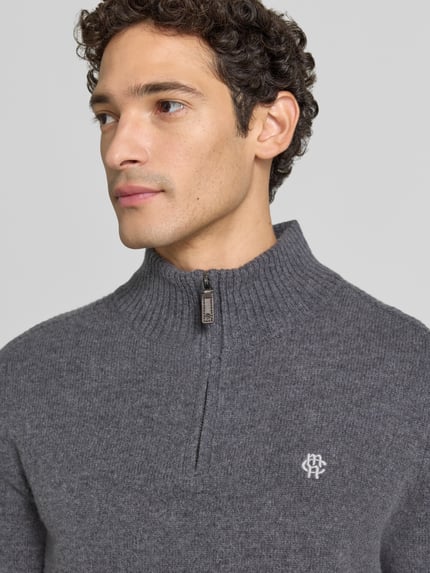 Männermodel trägt Regular Fit Strickpullover aus reiner Wolle von MCNEAL in Grau mit Logo-Stickerei und Troyer-Kragen, Nahaufnahme Oberkörper.
