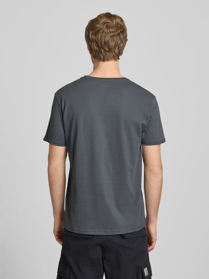 Männermodel trägt T-Shirt mit Logo und Rundhalsausschnitt von Alpha Industries, Reine Baumwolle, Regular-Fit, Rückenlänge 68 cm, Ganzkörperansicht Rückansicht