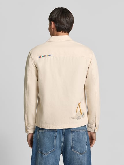 Männermodel trägt Regular Fit Overshirt mit Motiv-Prints- und -Applikationen von Scotch & Soda, helle Baumwolle, Rückenansicht, KI-modifiziertes Bild.