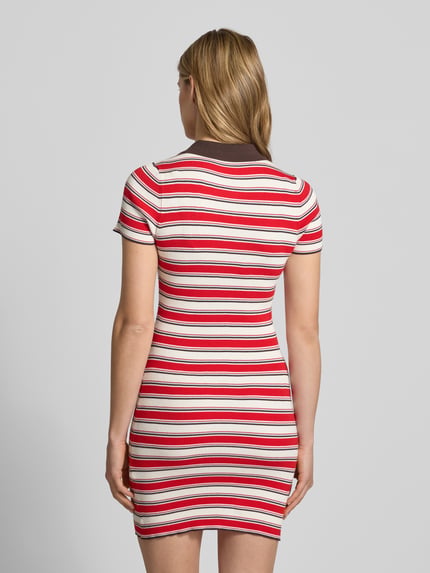 Modelka kobieca ma na sobie Polokleid aus Viskose-Mix mit kurzer Knopfleiste Modell 'Elenia' od LeGer by Lena Gercke, czerwono-białe paski, krój slim fit, długość mini, kołnierzyk polo, Szerokość w rozmiarze 36: 33 cm, długość tyłu w rozmiarze 36: 83 cm, długość rękawa w rozmiarze 36: 19 cm, widok całej sylwetki od tyłu.