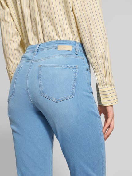 Frauenmodel trägt Flared Fit Jeans im 5-Pocket-Design Modell 'Carola' von Brax in Hellblau, elastischer Baumwoll-Mix, Detailaufnahme Rückansicht.