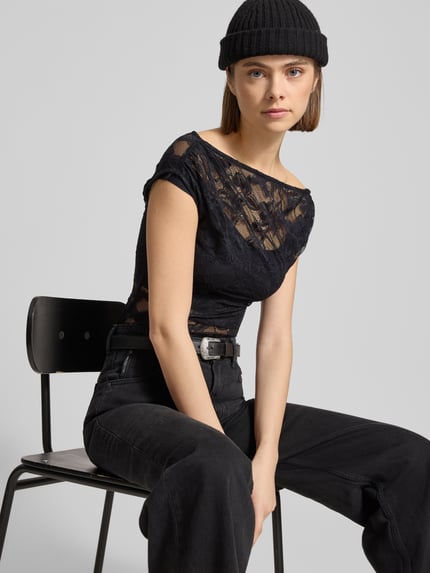 Vrouwenmodel draagt Slim Fit T-Shirt uit kant in asymmetrisch design van Gina Tricot, zwart, semitransparant, elastisch, heuplengte. Nahaufnahme bovenlichaam.