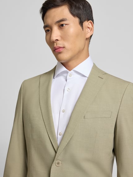 Männermodel trägt Slim Fit Anzugsakko mit Schulterpolstern von s.Oliver BLACK LABEL in Melange-Optik, feine Webstruktur, Nahaufnahme Oberkörper.