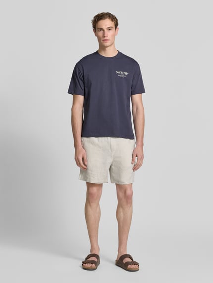 Männermodel trägt Relaxed Fit T-Shirt aus reiner Baumwolle von Marc O'Polo in Unifarbe mit Label Print, Rundhals, Regular Fit; Ganzkörperansicht von vorne.